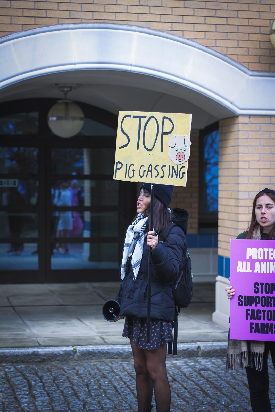 Activist holding placard: 'Stop gassing pigs'